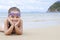 Happy little girl lying on the sand on the beach Female preschooler kid