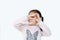 Happy little girl making triangle with looking through her hands isolated over white background