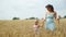 Happy Little Girl with Mom Crossing Wheat Field