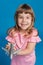 Happy little girl in pink dress holds airplane in hand and laughs, dreams of traveling, vacation concept