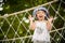 Happy little girl playing climbing on the rope bridge