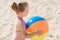 Happy little girl playing inflatable ball on beach