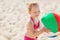 Happy little girl playing inflatable ball on beach