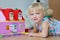 Happy little girl playing with plastic blocks