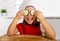 Happy little girl in red apron and cook hat playing in the kitchen with cucumber slices on eyes