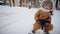 Happy little girl rides a snow sled along snow covered park pathway. Family fun outdoors