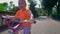 Happy little girl riding a pink bike