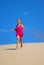 Happy little girl running down sand dunes