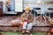 Happy little girl sitting on porch of house with pumpkins. home decorating for Halloween or Thanksgiving. Smiling Child in autumn