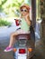 Happy little girl sitting in a vintage scooter in the street we