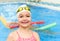 Happy little girl swimming in the pool. Caucasian child is playing fun in the kindergarten pool