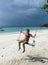 Happy little girl on swing at the beach