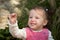 Happy little girl toddler excitedly showing off a pebble.