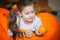 Happy little girl wallows in an orange bean bag chair with a ripe orange fruit