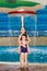 Happy little girls in identical swimsuits posing near the children`s pool in the water Park. Child learns to swim