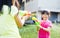 Happy little girls playing water guns in the park