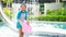 Happy little girls in swimsuits standing with kickboard in the swimming pool