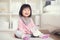 Happy little japanese girl playing on white capet at home