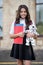 Happy little kid back to school in uniform holding books and toy dog in schoolyard, knowledge day