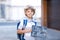 Happy little kid boy with backpack or satchel. Schoolkid on the way to school. Healthy adorable child outdoors On desk