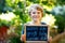 Happy little kid boy with chalk desk in hands. Healthy adorable child outdoors On desk When I grow up I want to be in