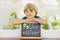 Happy little kid boy with chalk desk in hands. Healthy adorable child outdoors On desk - police officer - in German as