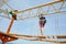 Happy little kid boy climbing on high rope course trail. Active child making adventure and action on family vacations