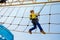 Happy little kid boy climbing on high rope course trail. Active child making adventure and action on family vacations