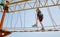 Happy little kid boy climbing on high rope course trail. Active child making adventure and action on family vacations