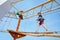 Happy little kid boy climbing on high rope course trail. Active child making adventure and action on family vacations