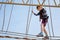 Happy little kid boy climbing on high rope course trail. Active child making adventure and action on family vacations