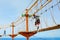 Happy little kid boy climbing on high rope course trail. Active child making adventure and action on family vacations