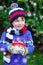 Happy little kid boy drinking hot cocoa and chocolate drink and marshmallows. Funny child in winter sweater, cap, long