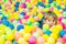 Happy little kid boy playing at colorful plastic balls playground high view. Funny child having fun indoors