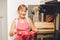 Happy little kid girl holding tray of freshly baked muffins