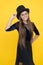 Happy little kid wear black party dress with fashion hat for holiday celebration yellow background, halloween