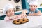 happy little kids in chef hats eating tasty cookies