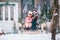 Happy little kids sitting on the porch of the Christmas decorated house outdoor