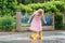 Happy little preschool girl wearing yellow rain boots and walking during puddles. Cute child in colorful clothes jumping