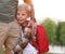 Happy little schoolboy hugging leg of his father on the way to school on 1st of September