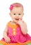 Happy little sly baby girl in bright multicolored festive dress