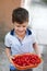 Happy little smiley kid holding cherries in bowl