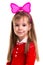 Happy little smiling blond girl in a red dress with a pink band bow on the white isolated background.