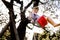 Happy little toddler girl having fun on swing in domestic garden. Smiling positive healthy child swinging on sunny day