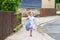 Happy little toddler girl running on street in the city, outdoors. Funny preschool child hild having fun with running
