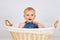 Happy little toddler sitting in the wicker basket