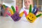 Happy looking kid playing with paints in his fingers, close-up photo