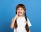 Happy lost tooth girl portrait, studio shoot on blue background