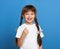 Happy lost tooth girl portrait, studio shoot on blue background