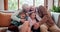 Happy, love and children hugging grandparents on a sofa in the living room at modern home. Smile, bonding and young kids